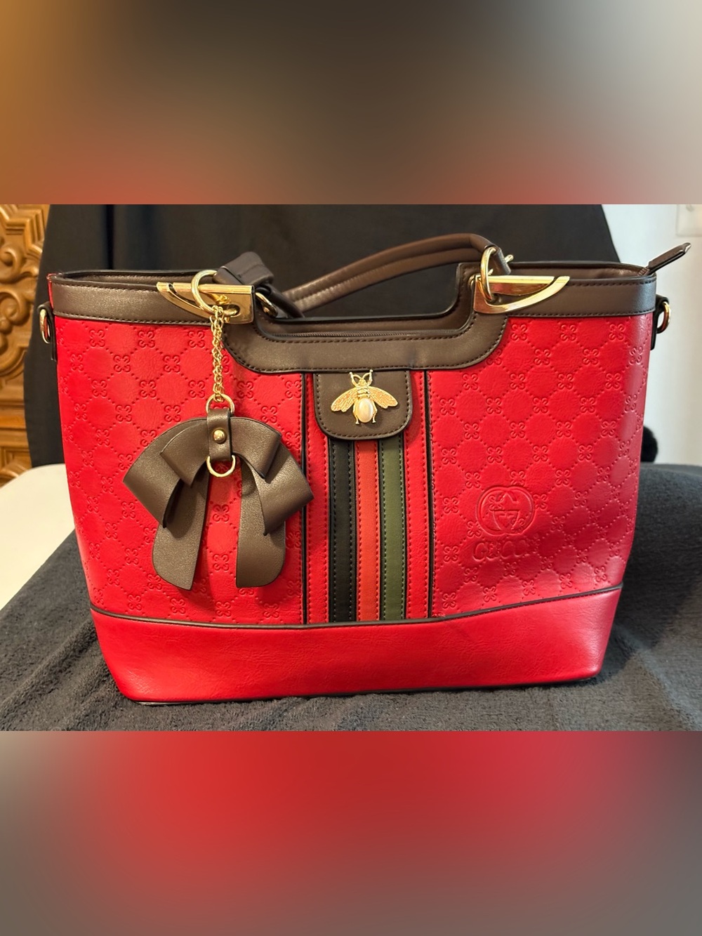 Red faux-leather Structured Tote with Brown Trim and Signature Bee Accent.